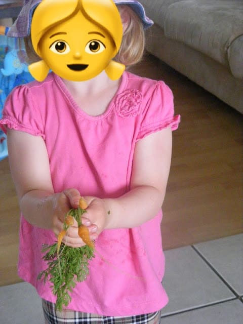 girl-holding-garden-grown-carrots