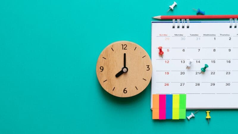 clock-and-calendar-on-teal-background